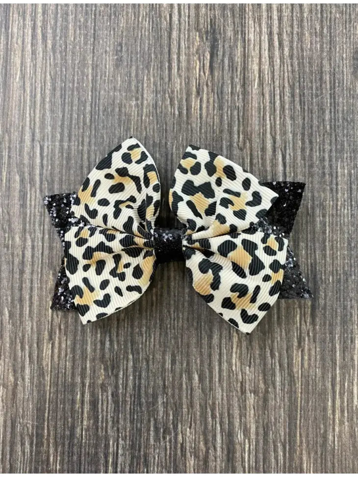Animal print and black glitter bow on a single alligator clip- approximately 4 inches across. - Brazos Avenue Market 